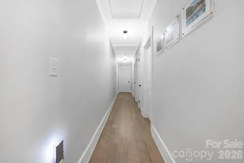 a view of a hallway with wooden floor and staircase