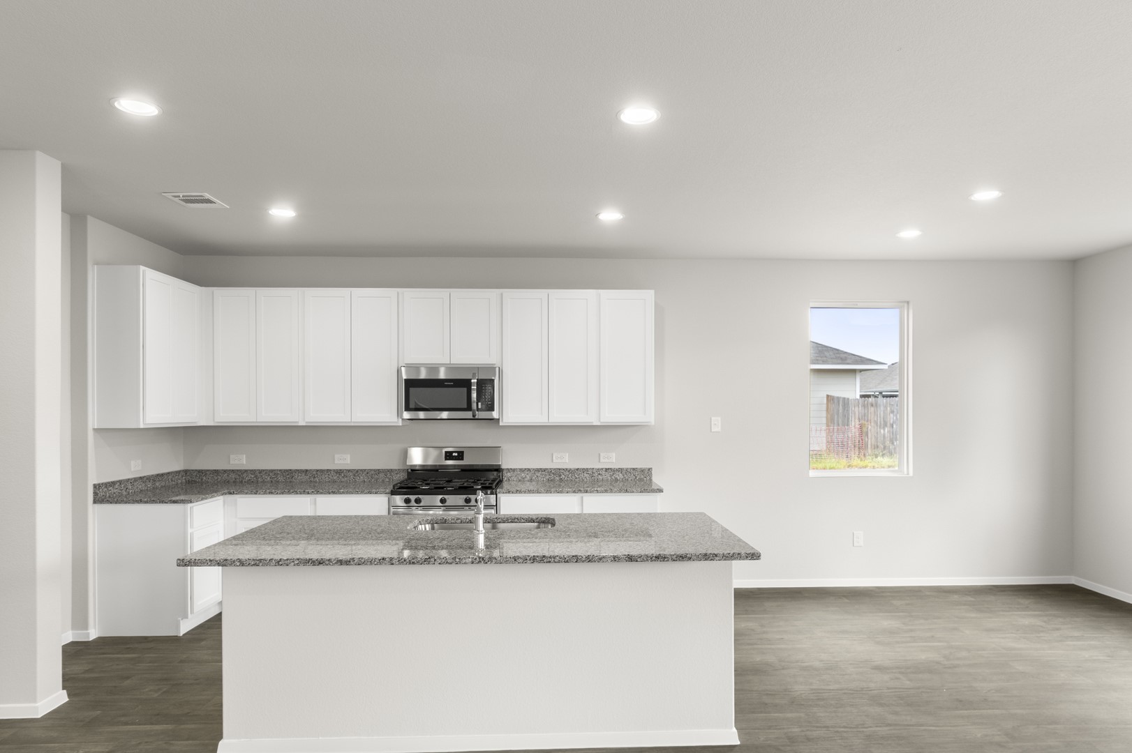 305 Jade Street Maxwell, TX 78656 - Photo 13 of 32 a kitchen with granite countertop stainless steel appliances a sink a stove a microwave a counter top and cabinets