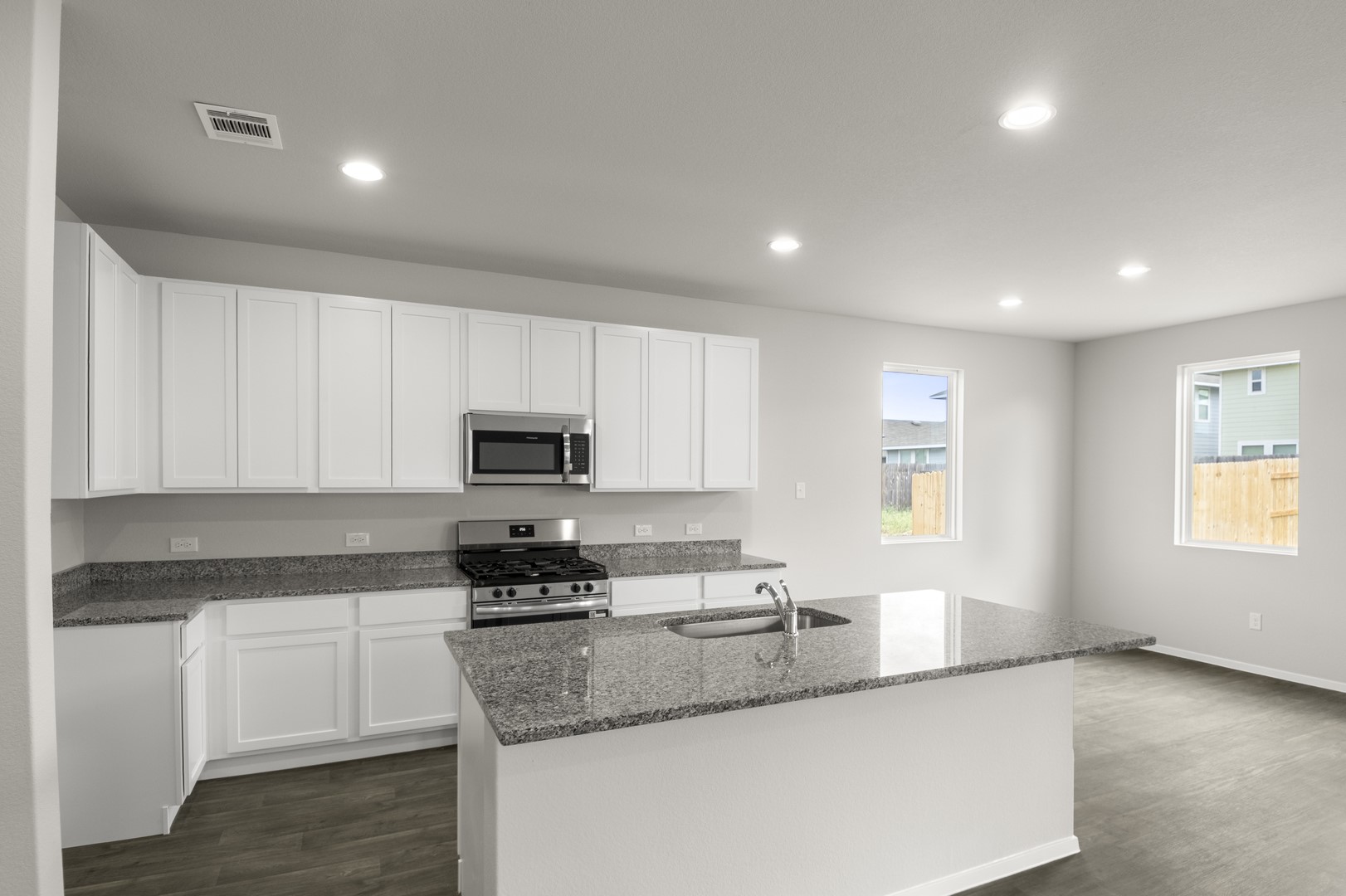 305 Jade Street Maxwell, TX 78656 - Photo 15 of 32 a kitchen with granite countertop a sink a stove a microwave a refrigerator and cabinets