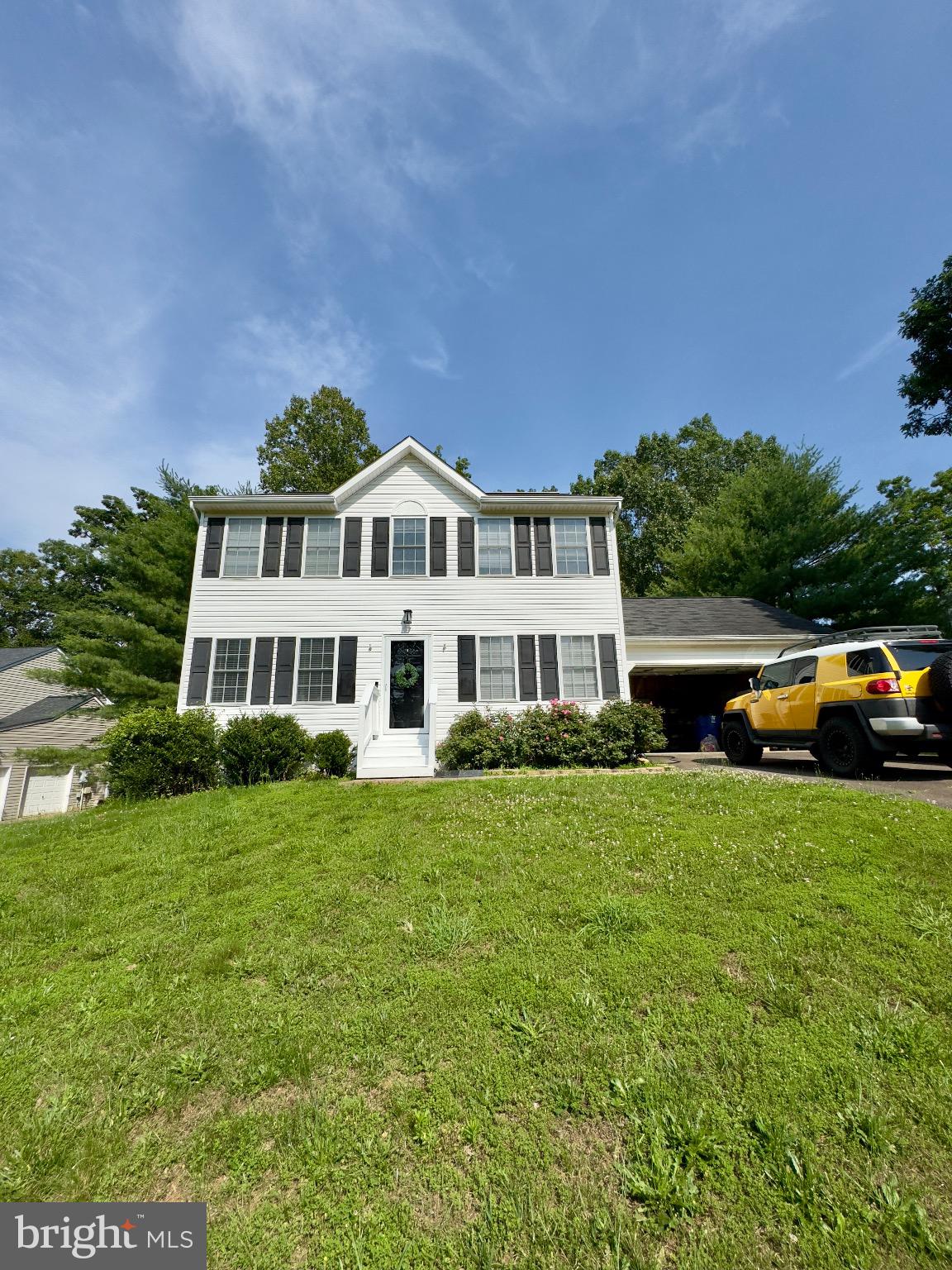 Charming two-story home with lush greenery.