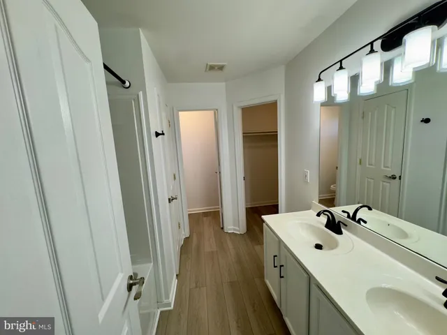 a bathroom with a double vanity sink and mirror with shower