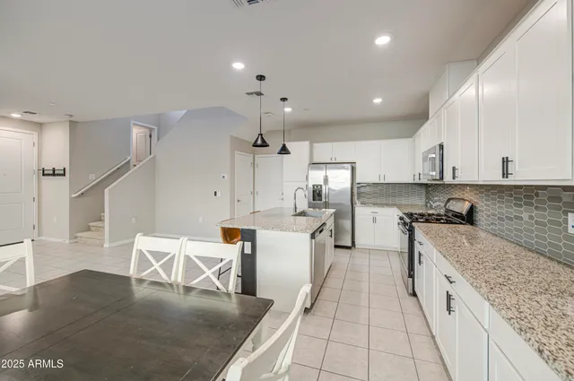 a kitchen with stainless steel appliances granite countertop a sink a stove and a granite counter tops