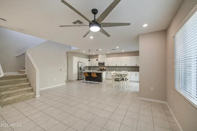 a kitchen with a dining table chairs and refrigerator