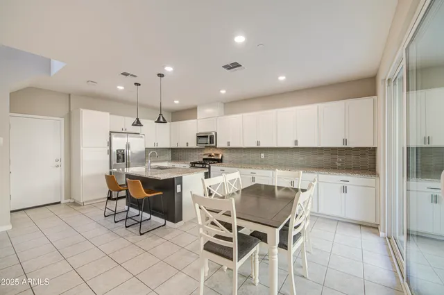 a large kitchen with a table and chairs