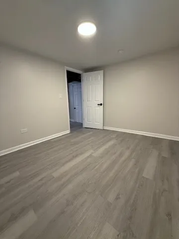 an empty room with wooden floor and a window