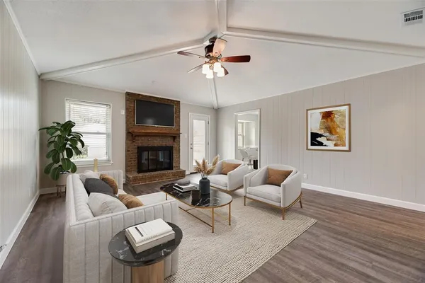 an empty room with wooden floor fireplace and windows