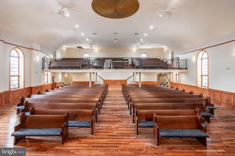 a room with table chairs and a view of kitchen