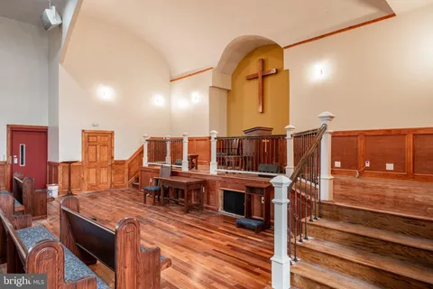 a view of living room kitchen with stainless steel appliances kitchen island granite countertop furniture and rug