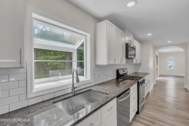 an empty room with a ceiling fan and windows