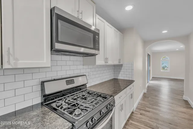 a view of a hallway with wooden floor and chandelier