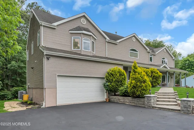 a front view of a house with a yard and potted plants