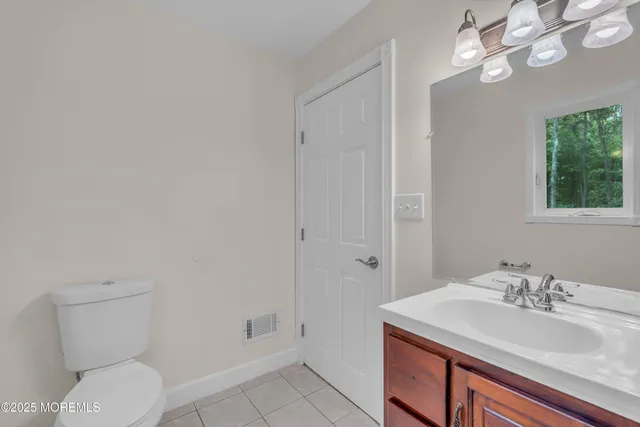 a bathroom with a granite countertop sink and a toilet