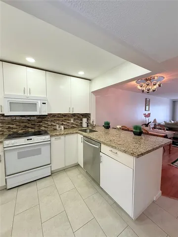 a kitchen with stainless steel appliances granite countertop a sink and cabinets