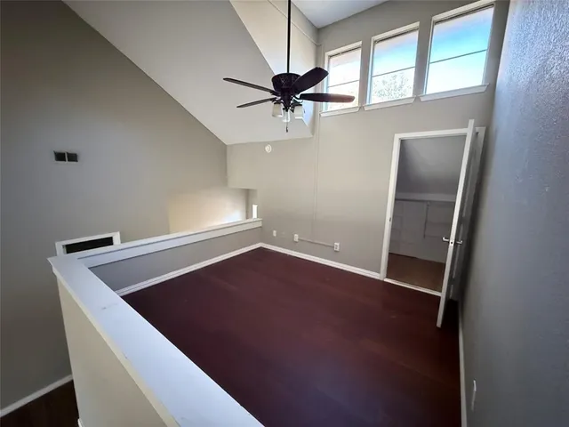 an empty room with windows and fan