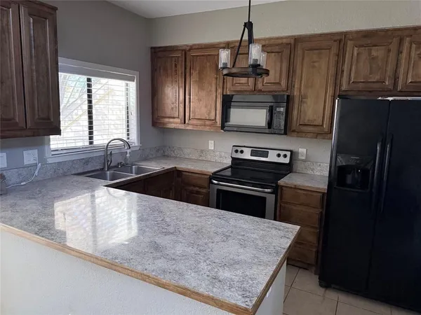 a kitchen with granite countertop a sink stainless steel appliances and a counter space