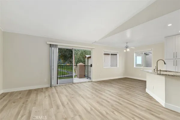 a view of a big room with wooden floor and windows
