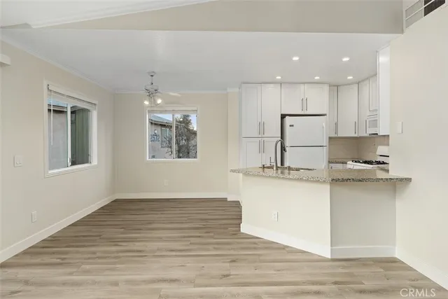 a view of an empty room with window and ceiling fan
