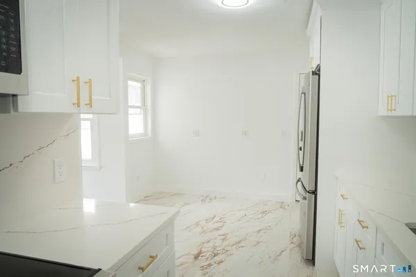 a kitchen with white cabinets and stainless steel appliances