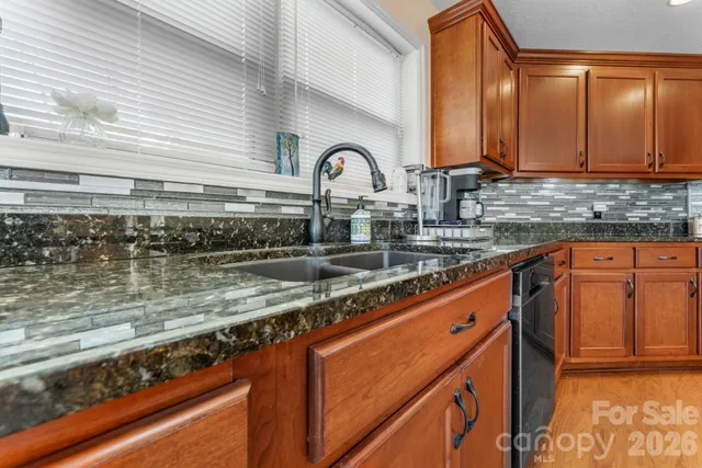 a kitchen with stainless steel appliances granite countertop a sink a stove and cabinets