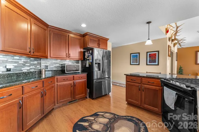 a kitchen with stainless steel appliances granite countertop a stove a sink dishwasher and a refrigerator