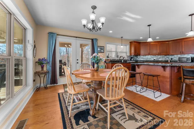 a view of a dining room with furniture a chandelier and wooden floor