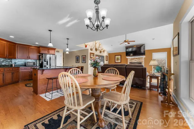 a view of a dining room with furniture a chandelier and wooden floor