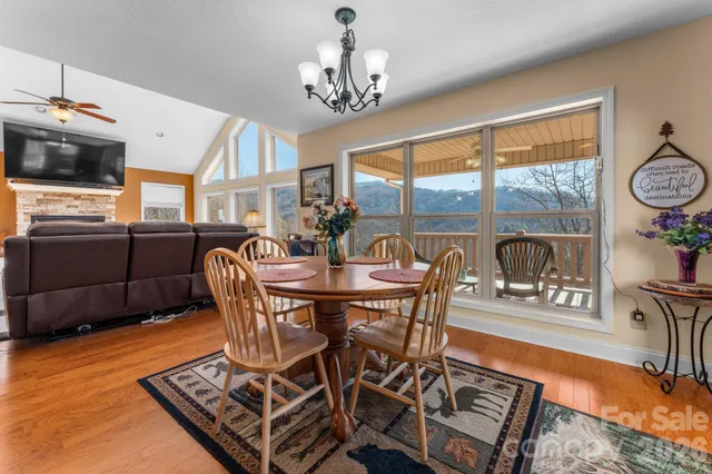 a view of a dining room with furniture a chandelier and wooden floor