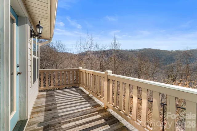 a view of a balcony with wooden floor and fence