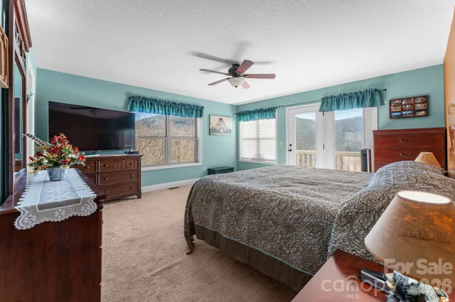 a spacious bedroom with a bed and a flat screen tv