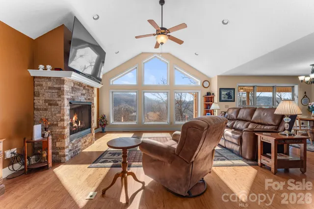 a living room with furniture a fireplace and a large window