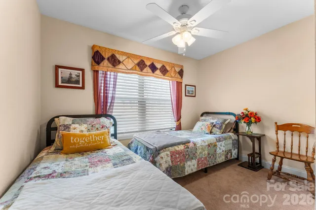 a bedroom with two beds and a chandelier