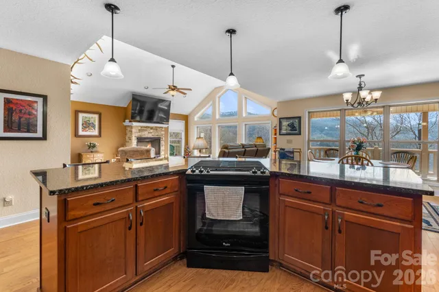 a kitchen with stainless steel appliances granite countertop a stove a sink and a wooden floors