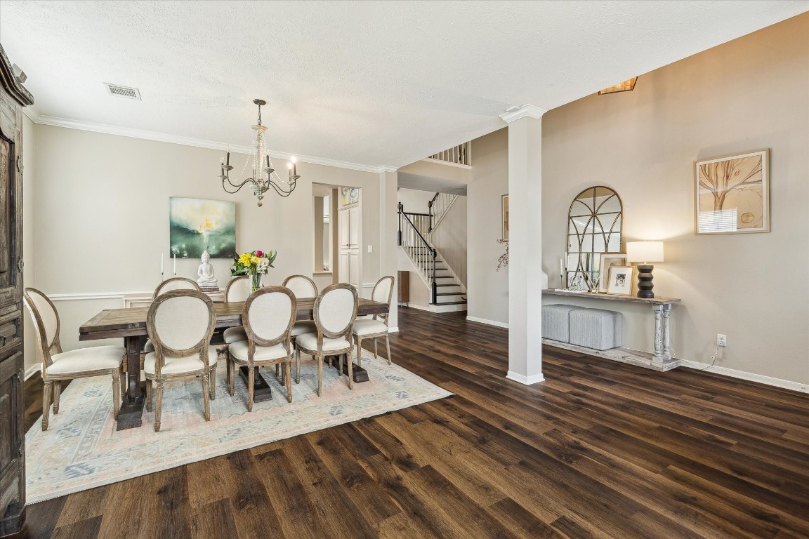 9831 Therrell Drive Houston, TX 77064 - Photo 13 of 44 a view of a dining room with furniture a chandelier and wooden floor