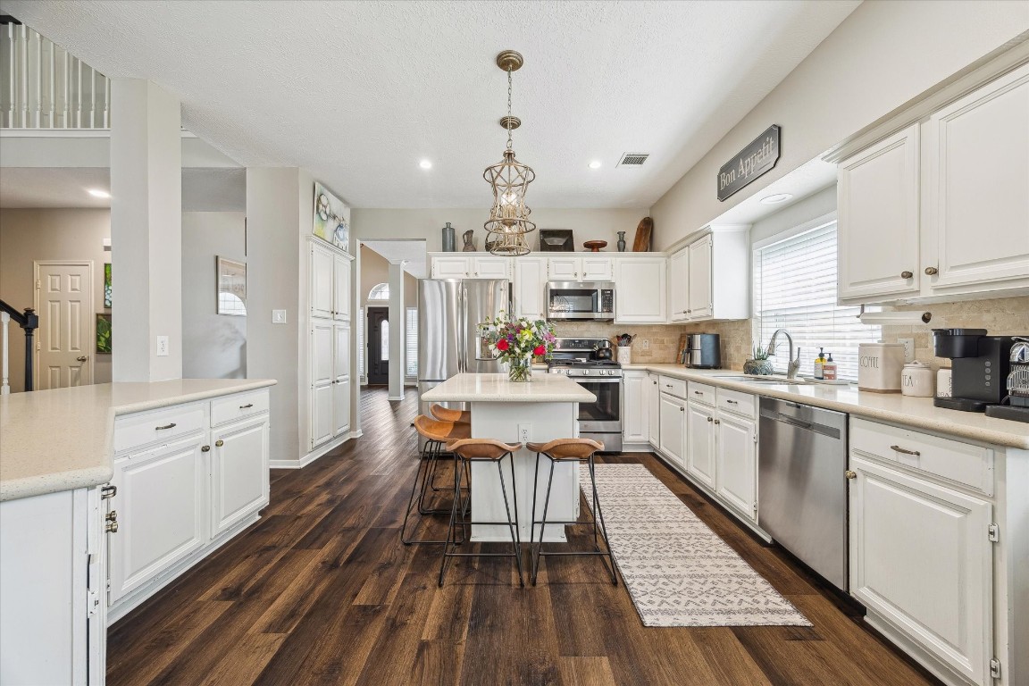 9831 Therrell Drive Houston, TX 77064 - Photo 16 of 44 a kitchen with granite countertop a refrigerator a sink dishwasher a dining table and chairs with wooden floor