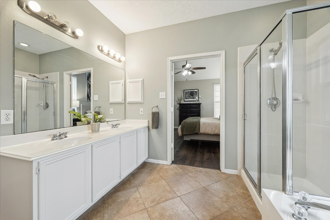9831 Therrell Drive Houston, TX 77064 - Photo 29 of 44 a en suite bathroom with a double vanity sink a mirror and a shower
