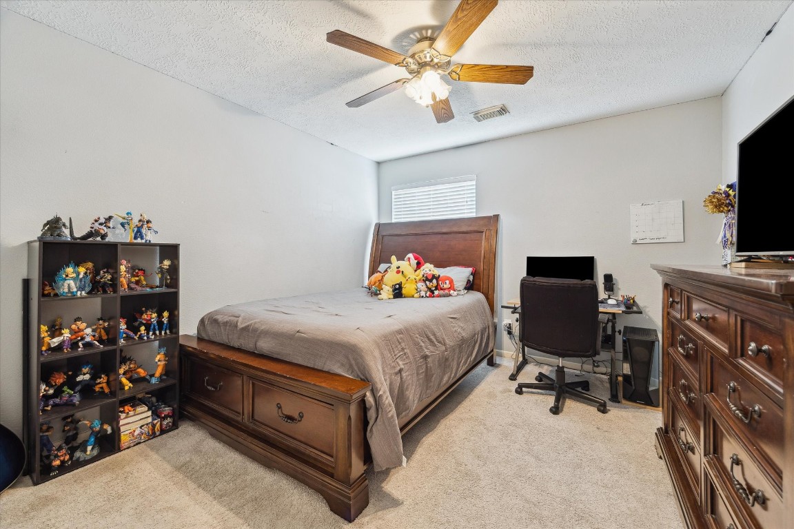 9831 Therrell Drive Houston, TX 77064 - Photo 36 of 44 a bedroom with a bed and a chandelier