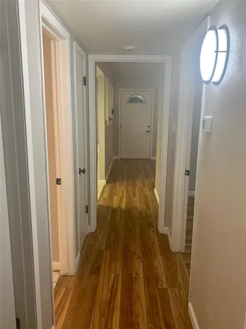 a view of a room with wooden floor mirror and window