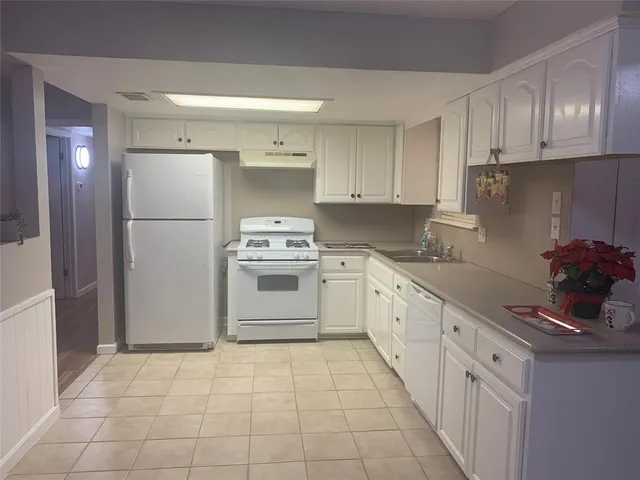 a kitchen with cabinets and white appliances