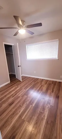 a view of a room with wooden floor and fan