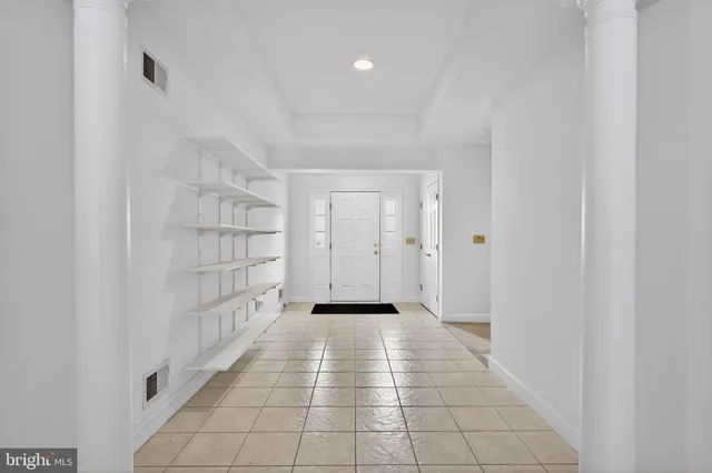 a view of a hallway with wooden floor and a bathroom