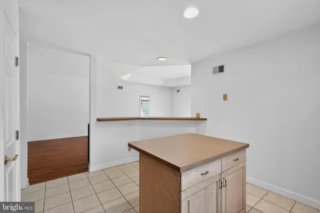 a kitchen with a sink cabinets and wooden floor