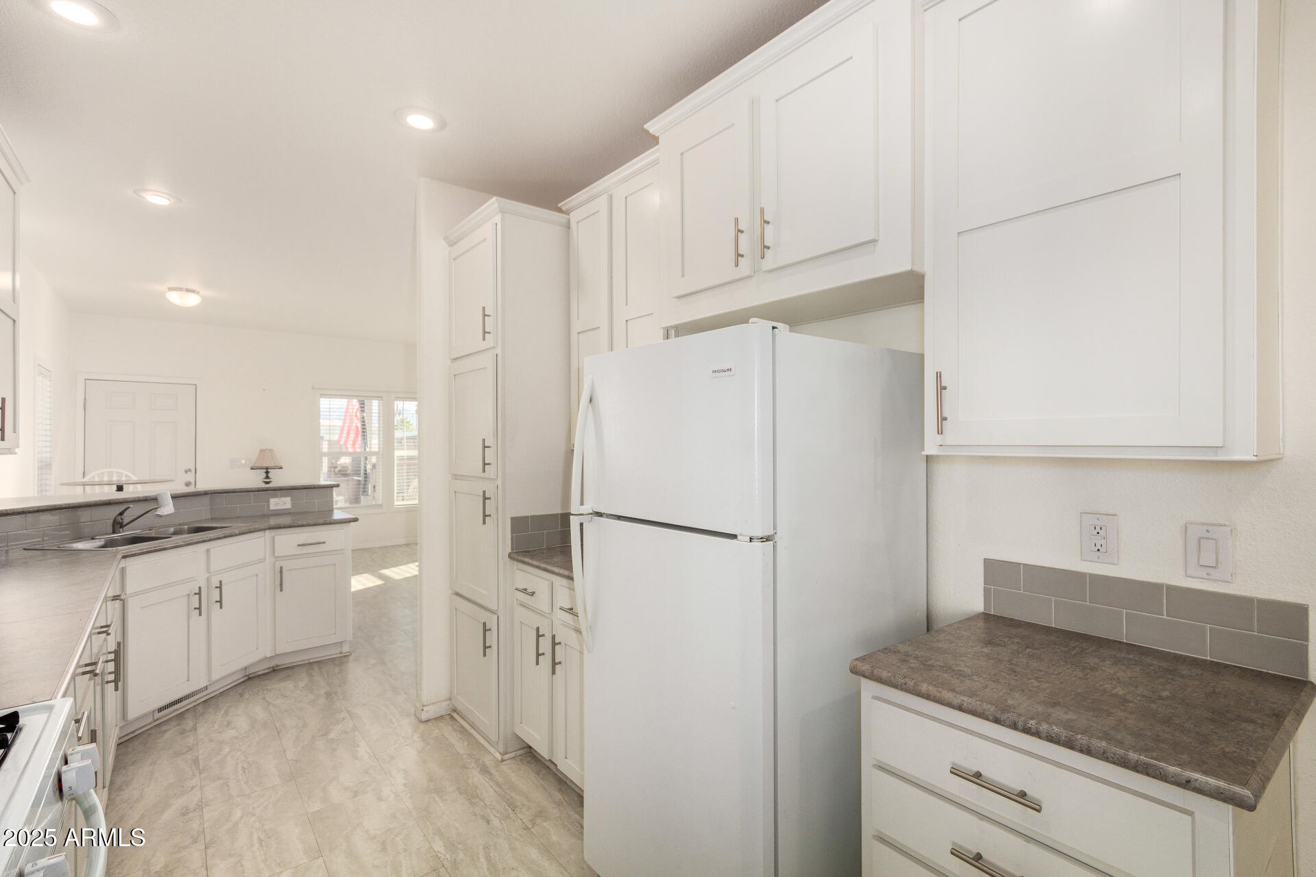 10540 East Apache Trail, Unit 93 Apache Junction, AZ 85120 - Photo 11 of 27 a kitchen with white cabinets and white appliances