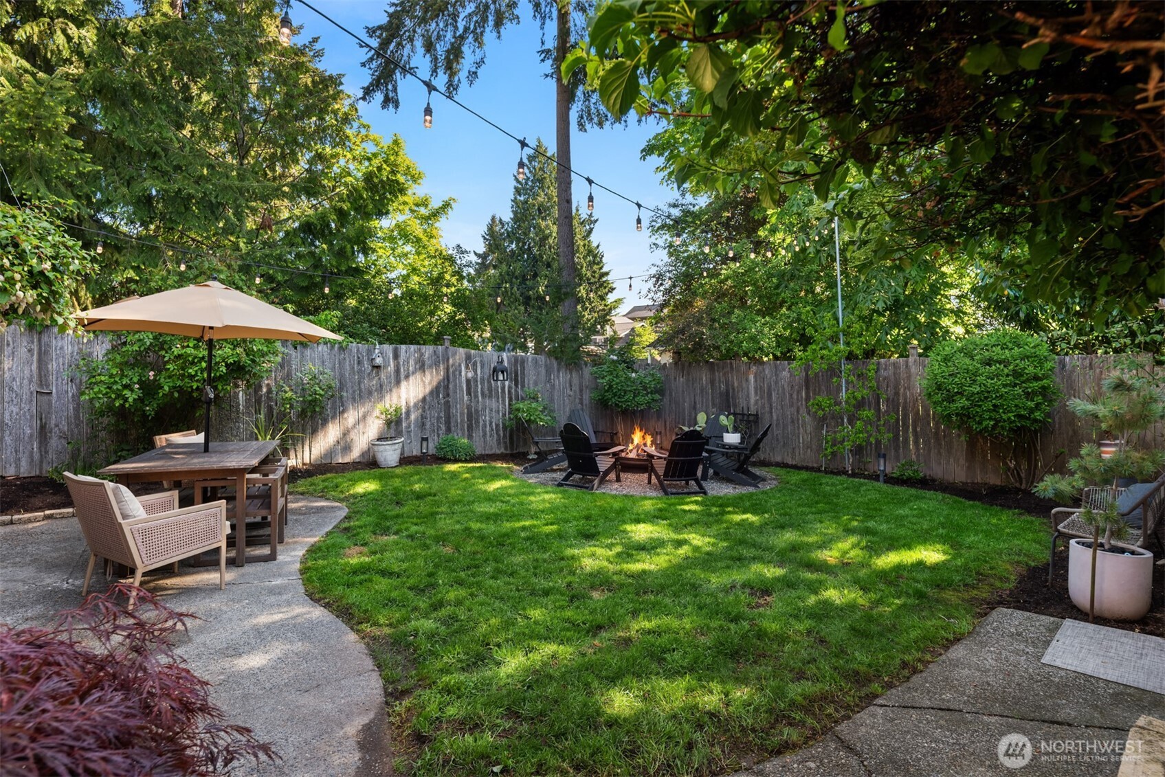 6422 49th Avenue Southwest Seattle, WA 98136 - Photo 17 of 20 a view of a backyard with table and chairs under an umbrella with wooden fence