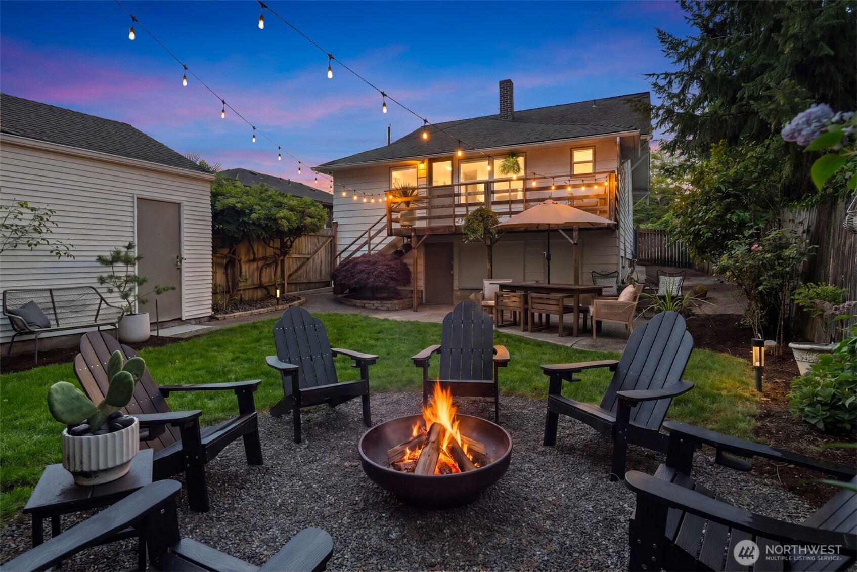 6422 49th Avenue Southwest Seattle, WA 98136 - Photo 18 of 20 a view of a patio with table and chairs potted plants and wooden fence