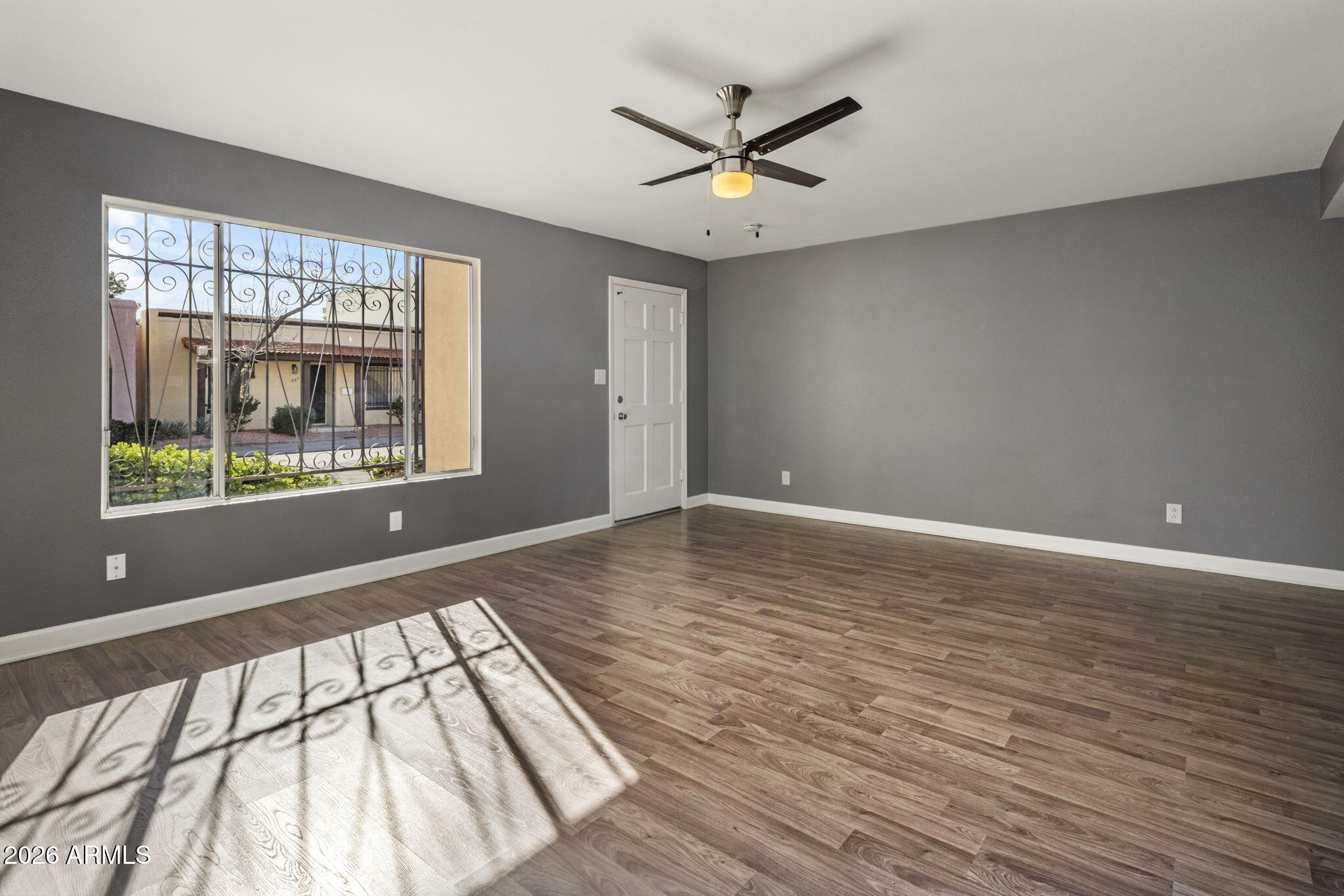 1842 West Marlette Avenue Phoenix, AZ 85015 - Photo 3 of 30 a view of an empty room with wooden floor and a window