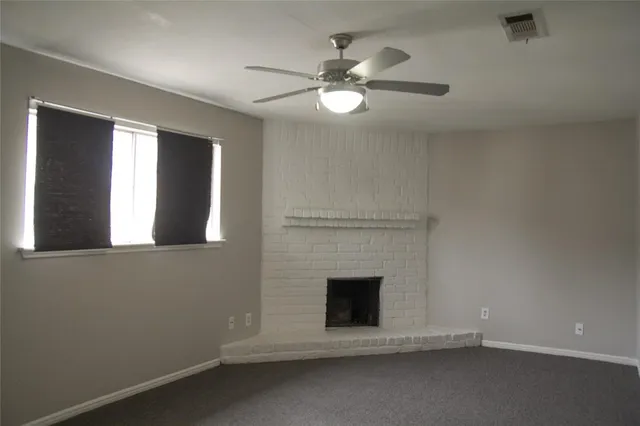 a view of a livingroom with a fireplace and fan