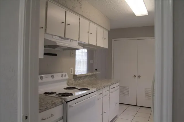 a kitchen with granite countertop white cabinets and white appliances