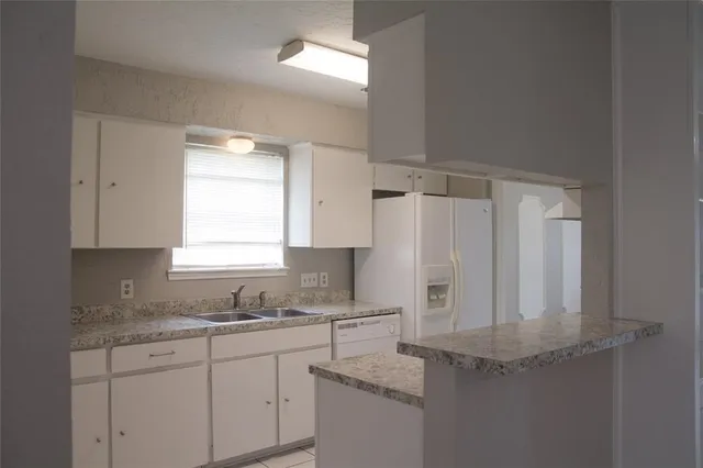 a kitchen with stainless steel appliances granite countertop a sink refrigerator and window