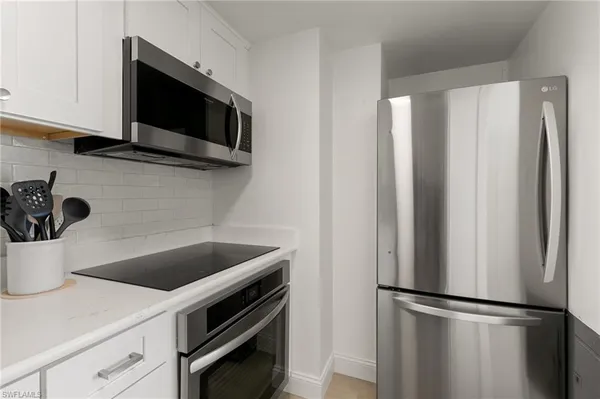 a kitchen with a microwave and a refrigerator