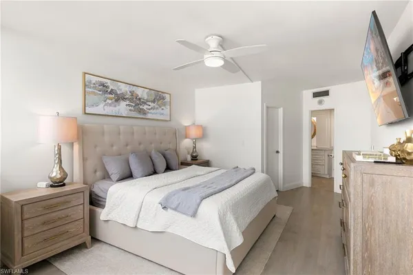 a bed room with a bed mirror and a night stand